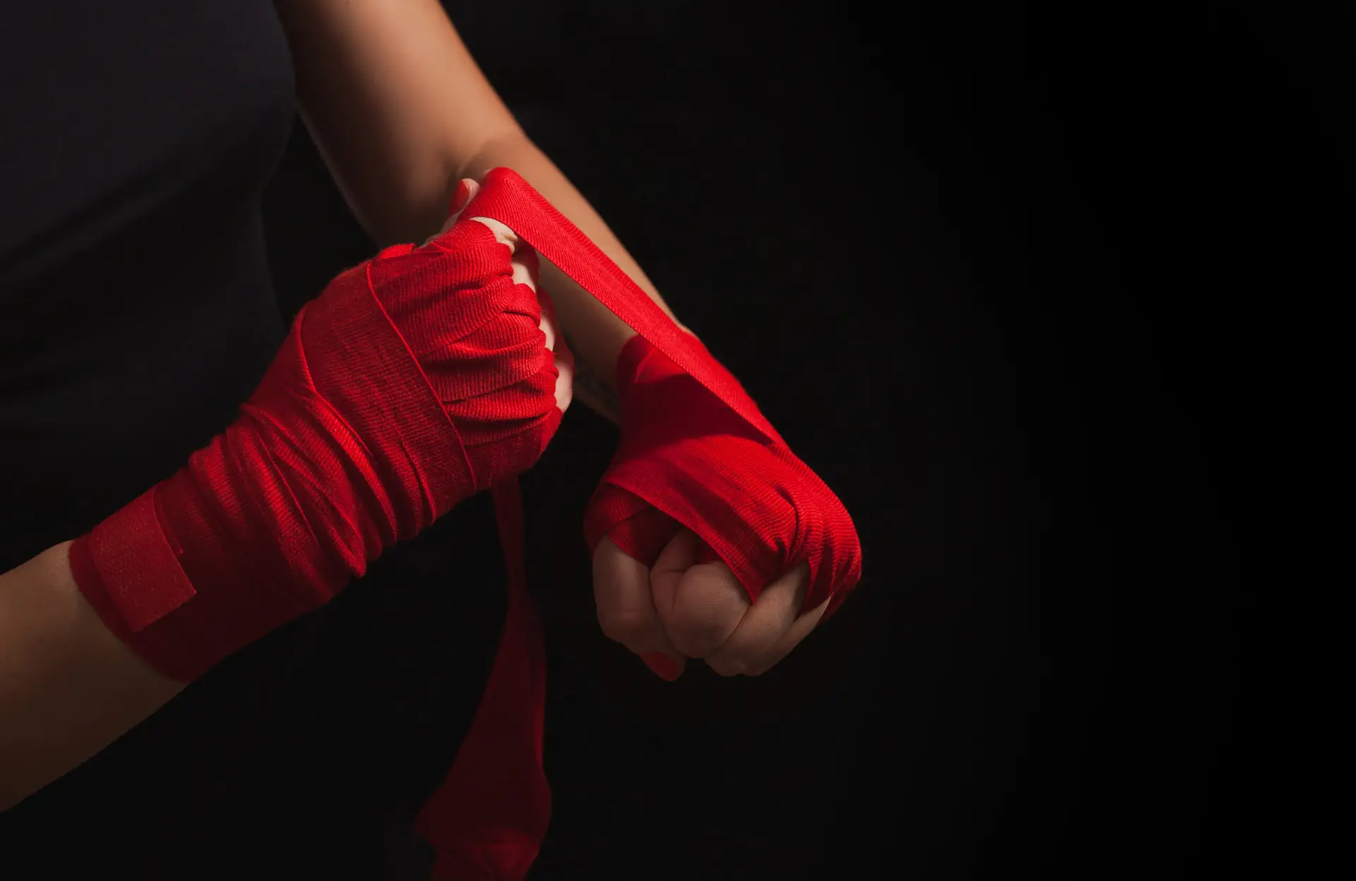 SRteam - femme mettant des bandes de boxe rouge